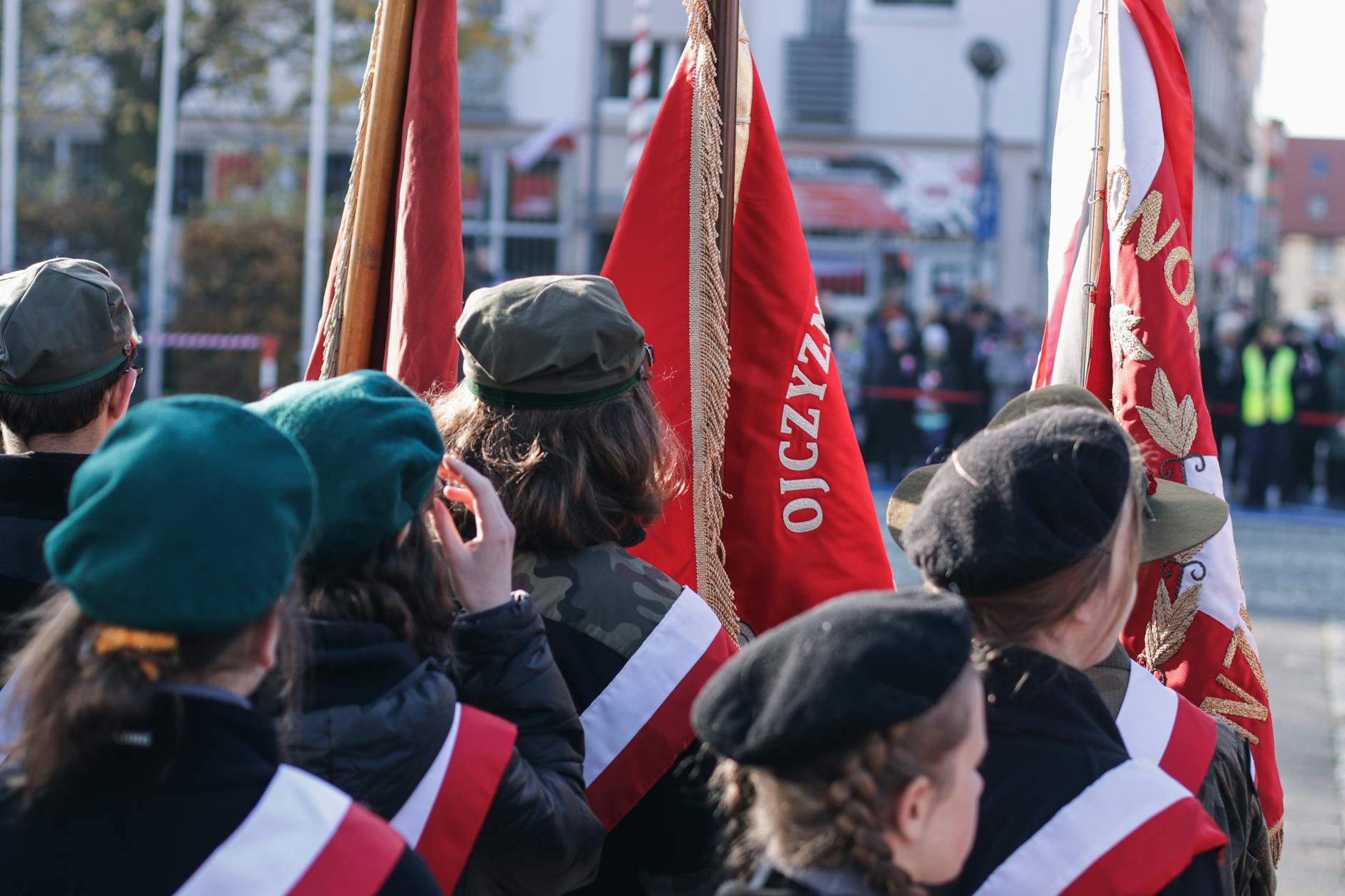 Ulica w Gozdnicy udekorowana polskimi flagami z okazji Święta Konstytucji 3 Maja, mieszkańcy gromadzą się na placu.